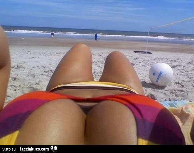Selfie tette e cosce di una ragazza sdraiata in bikini in spiaggia che prende il sole