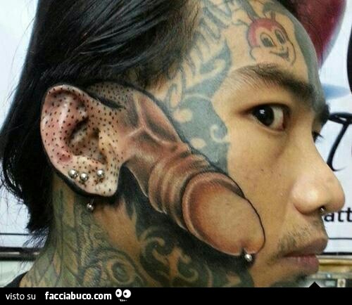 Pisello tatuato in faccia con l'orecchio come scroto