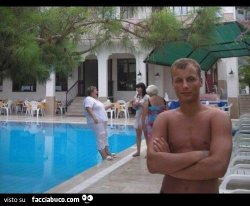 Il ragazzo si fa scattare una foto, e dietro di lui, la cicciona sta per cadere in piscina