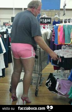 Uomo al negozio con calzoncino rosa e tacchi a spillo