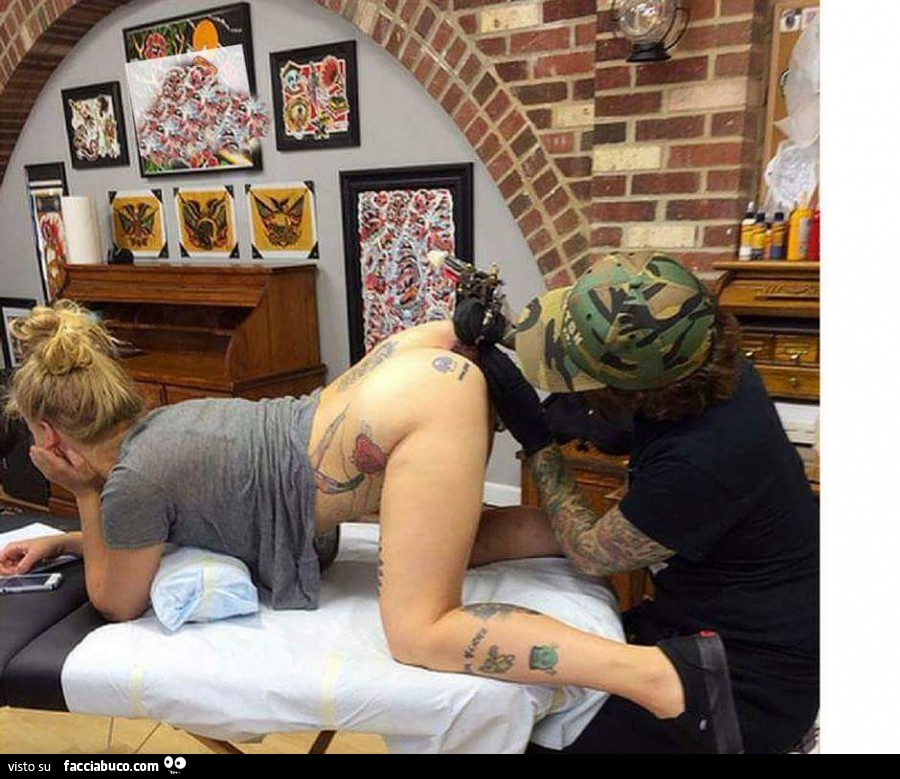 Ragazza semi nuda a pecora per farsi un tatuaggio nel sedere